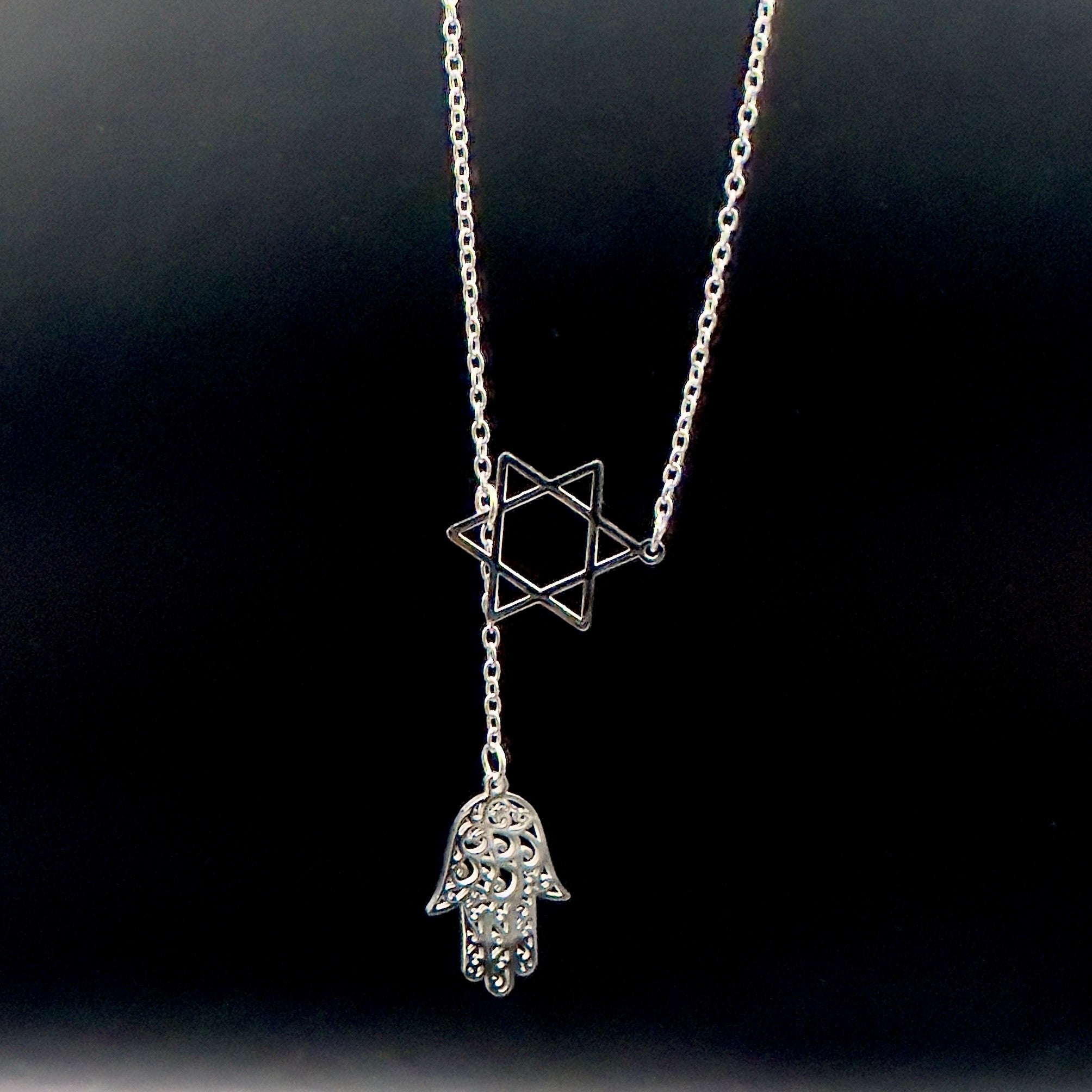 Star of David and Hamsa Drop Necklace - Simply Just Deals LLCStar of David and Hamsa Drop NecklaceJewelry Pendant Necklace42560115703831GoldThe Star of David and Hamsa Drop Necklace features a gold plated chain with a Star of David pendant and a delicate filigree Hamsa hand charm, beautifully set against a black background.