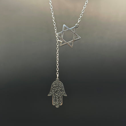 Star of David and Hamsa Drop Necklace - Simply Just Deals LLCStar of David and Hamsa Drop NecklaceJewelry Pendant Necklace42560115703831GoldThe Star of David and Hamsa Drop Necklace features a silver Star of David and an ornate Hamsa hand charm on a delicate chain, both gleaming softly against a dark, blurred background.